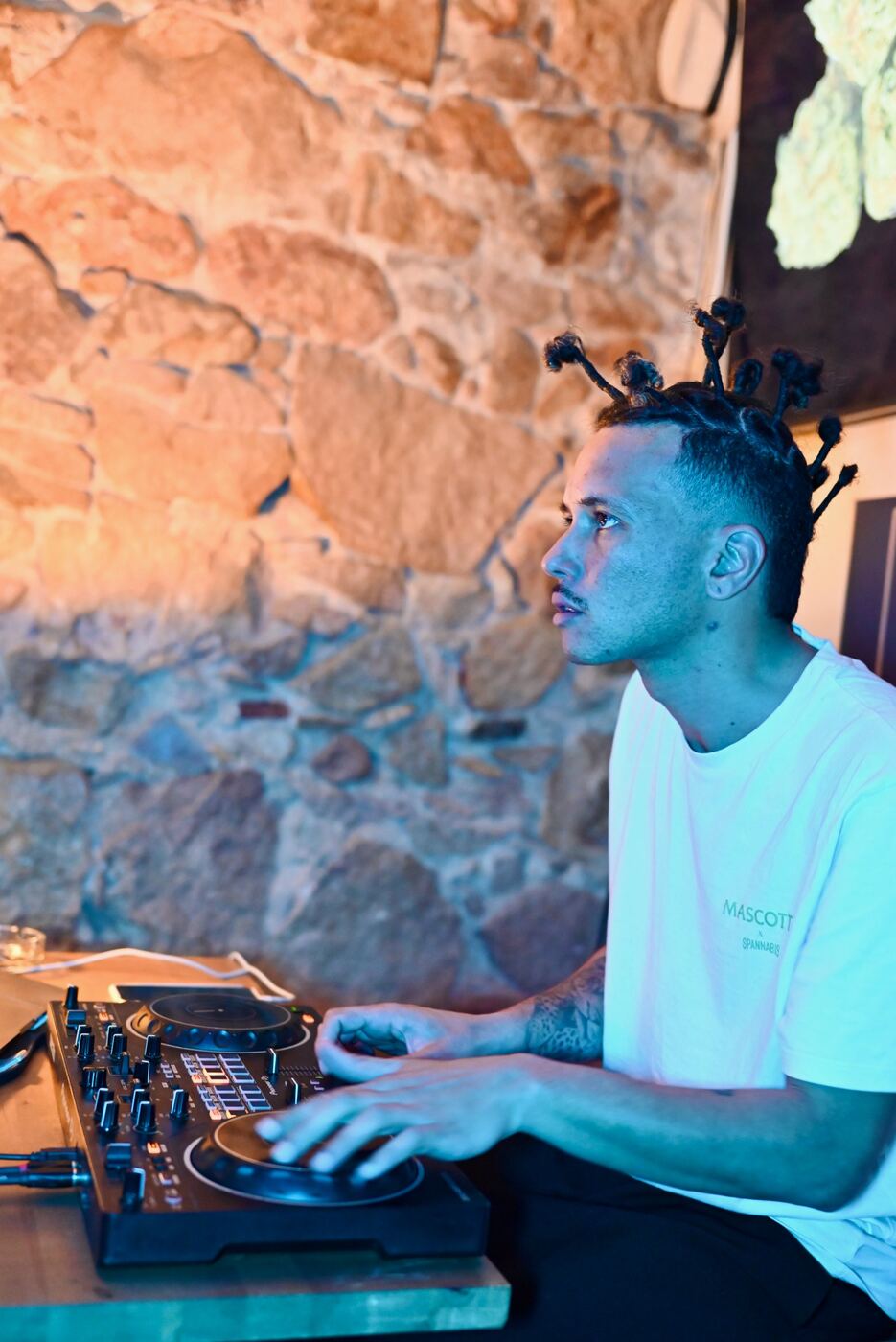 DJ playing in front of the stone wall at Blue Dream